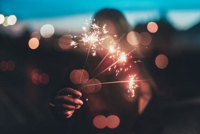 女人手里拿着烟花棒浅摄影
